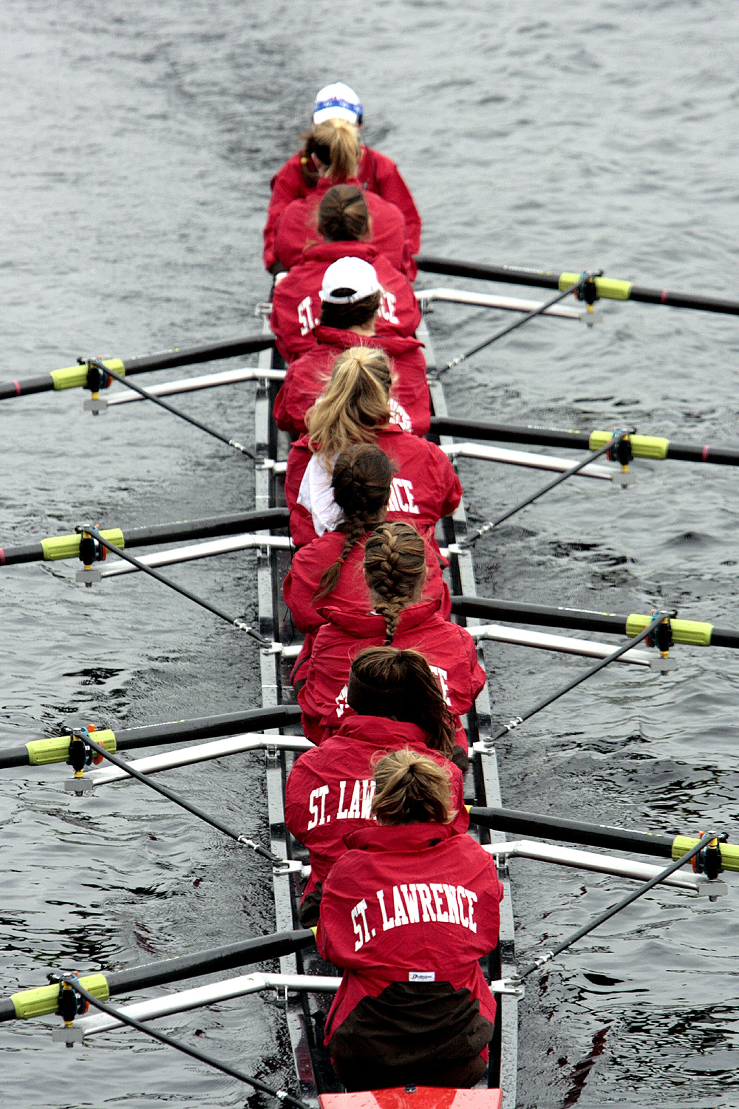 A rowing team paddling across a lake